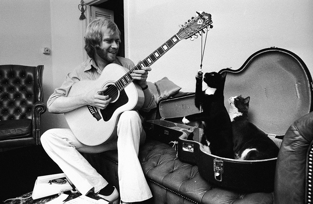 Long John Baldry playing guitar with cats