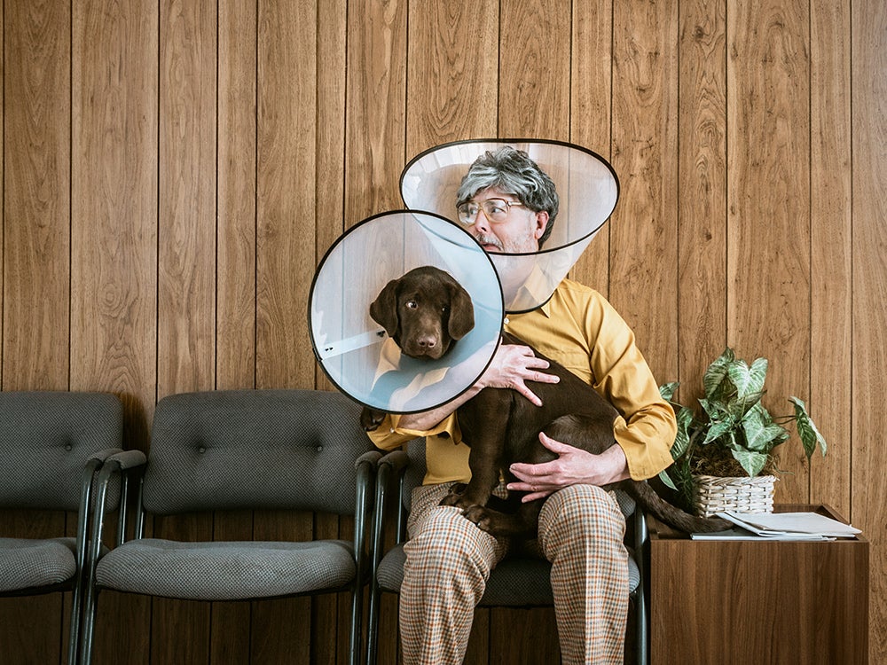 Man at Veterinarian Wearing Dog Cone