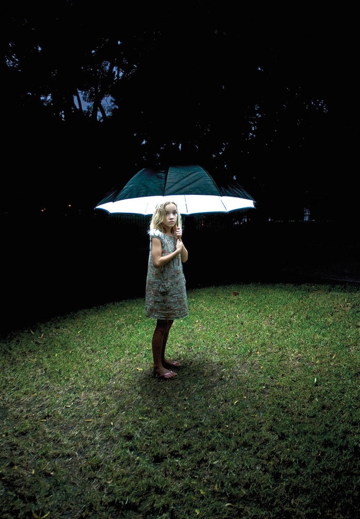 little girl with a lit umbrella at nigh