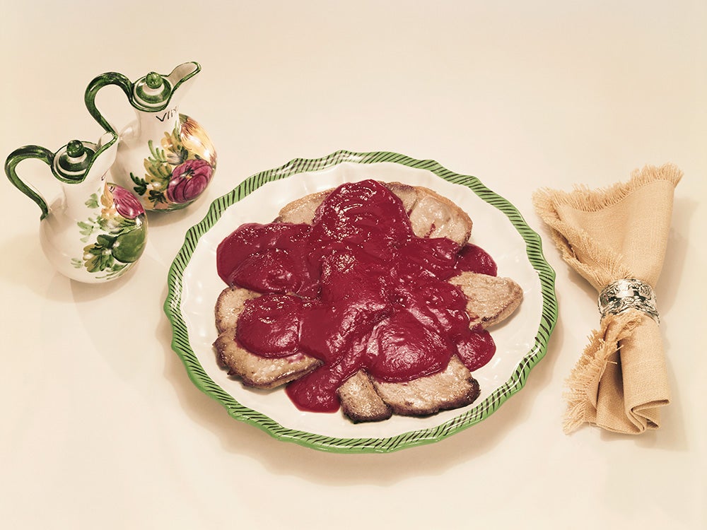 Plate of meat garnish with sauce jug and napkin