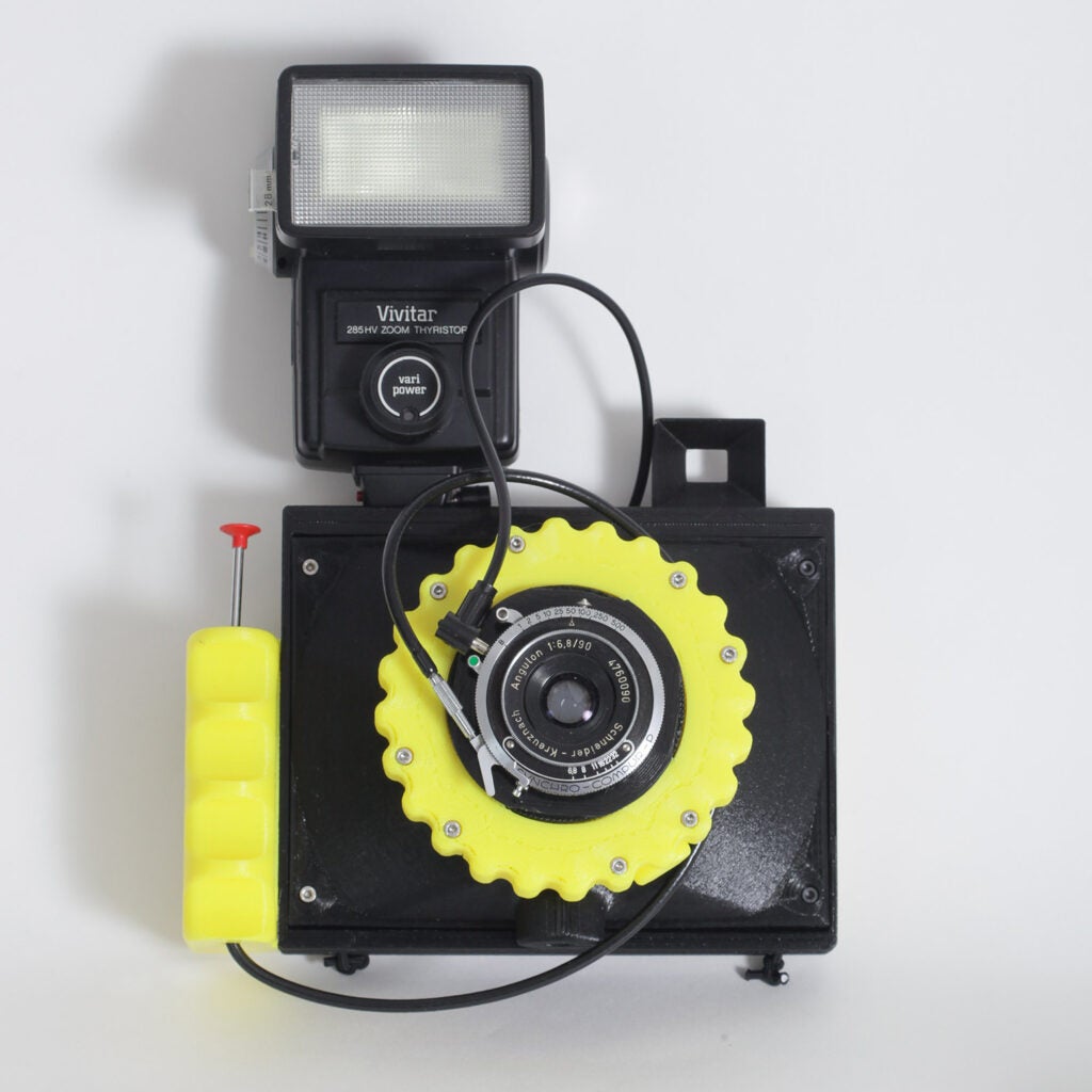 Yellow Cameradactyl OG 4x5 hand camera with flash