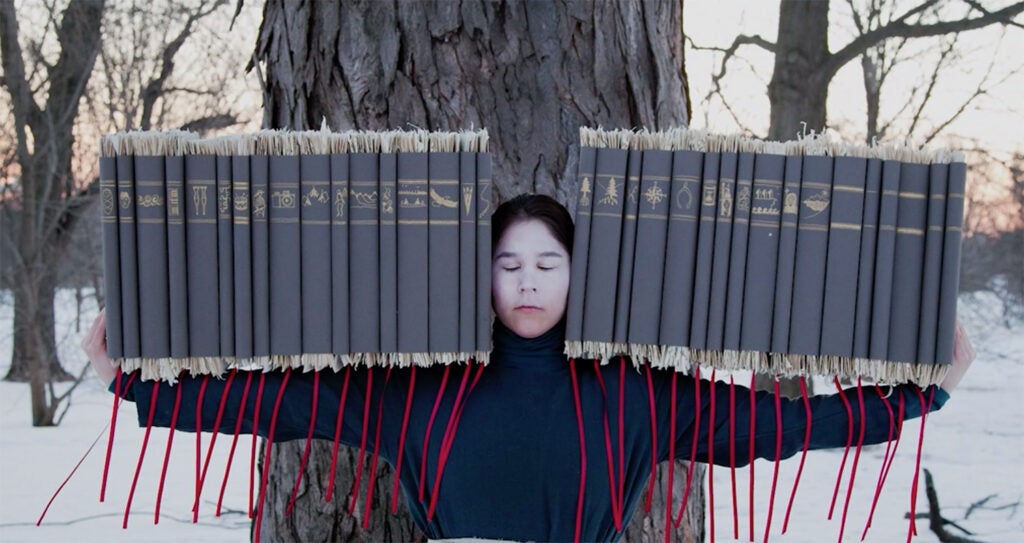 woman balancing many books on her arms