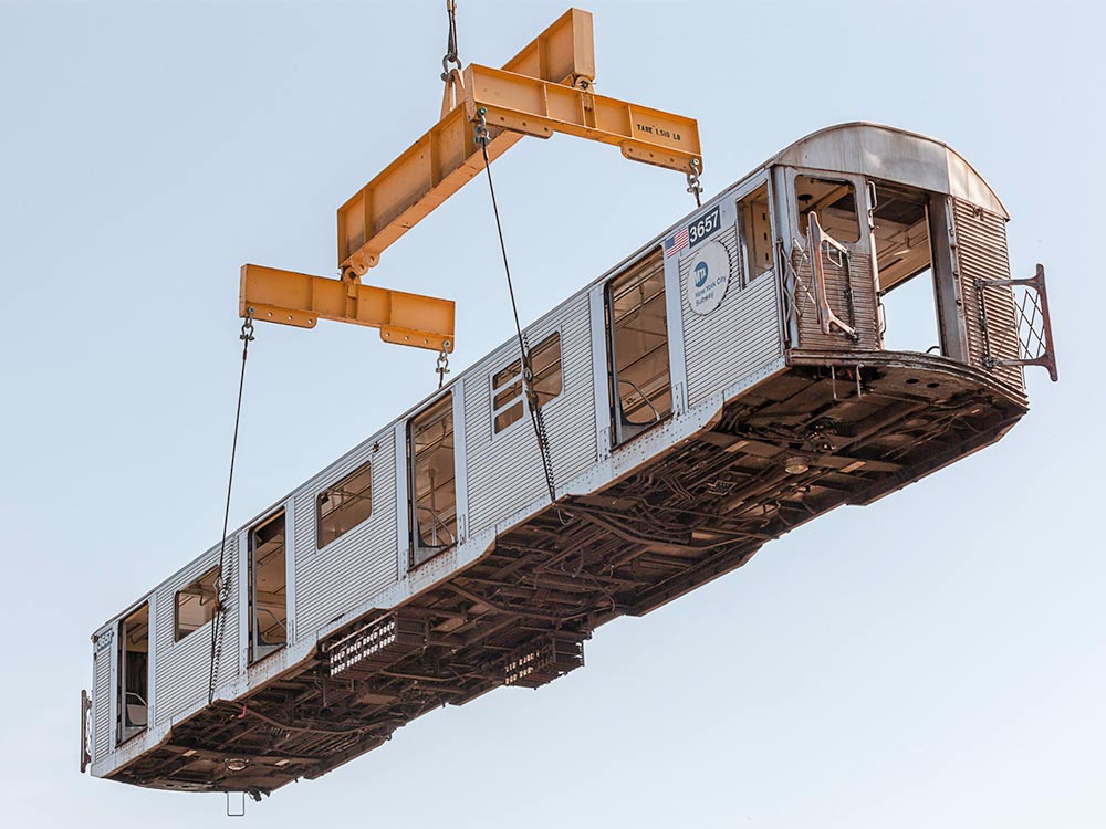 crane lifting a subway train