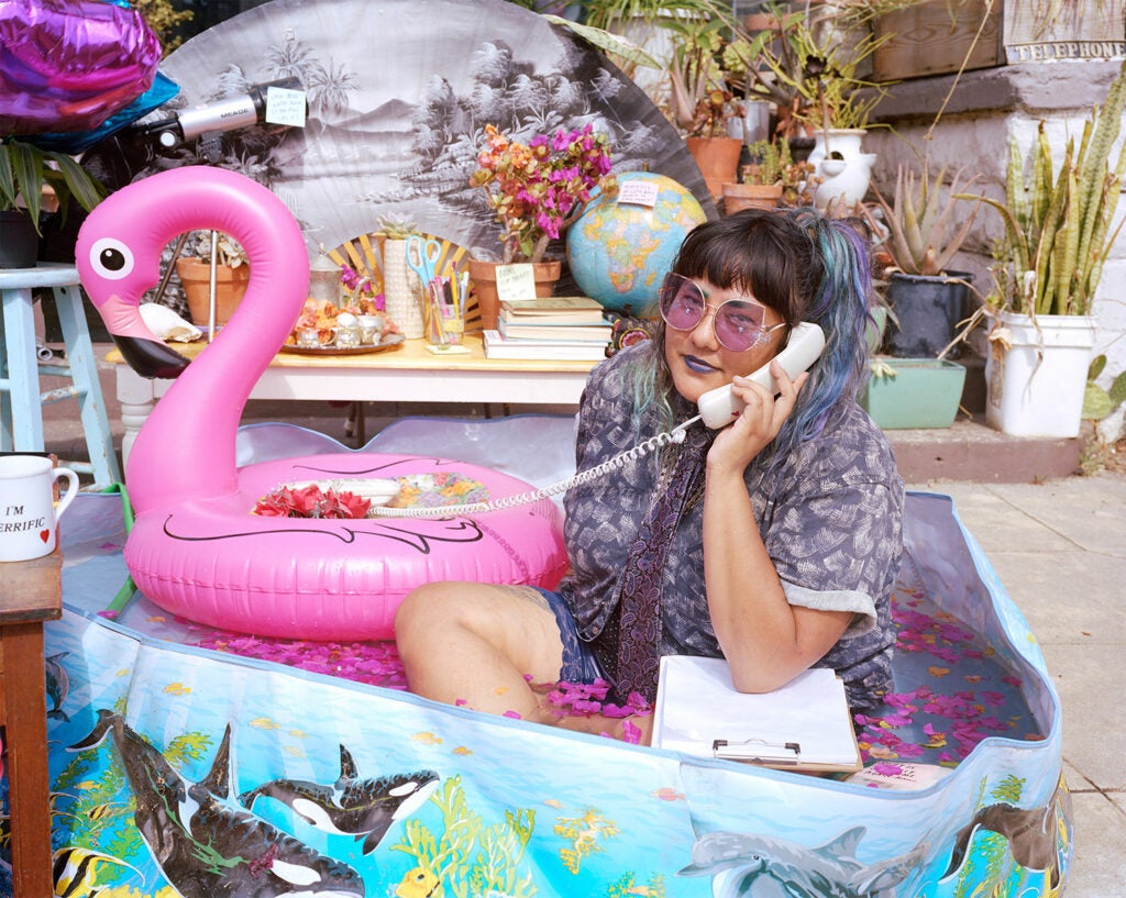 girl in a kiddy pool with a pink blow up flamingo