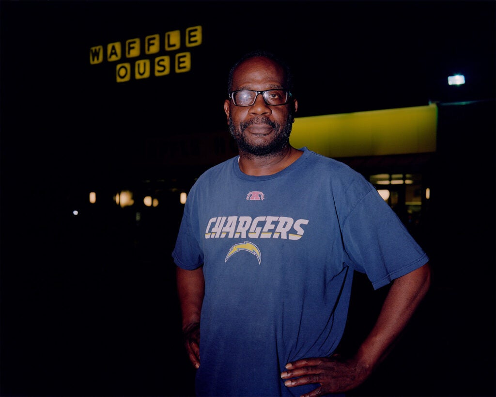 man outside waffle house in blue chargers shirt