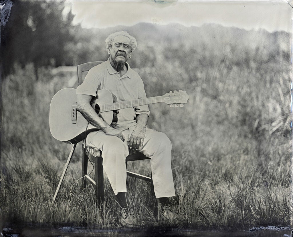 Boot Hanks with guitar in a field