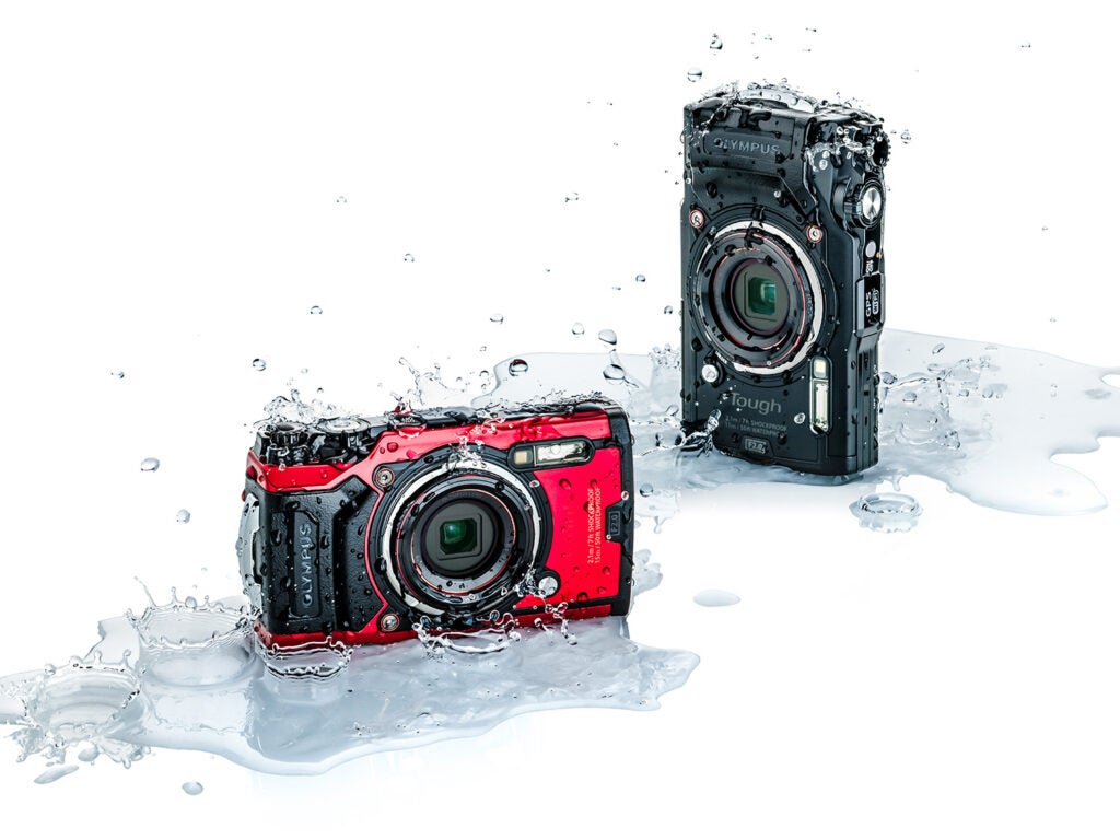 red and black olympus splashed with water
