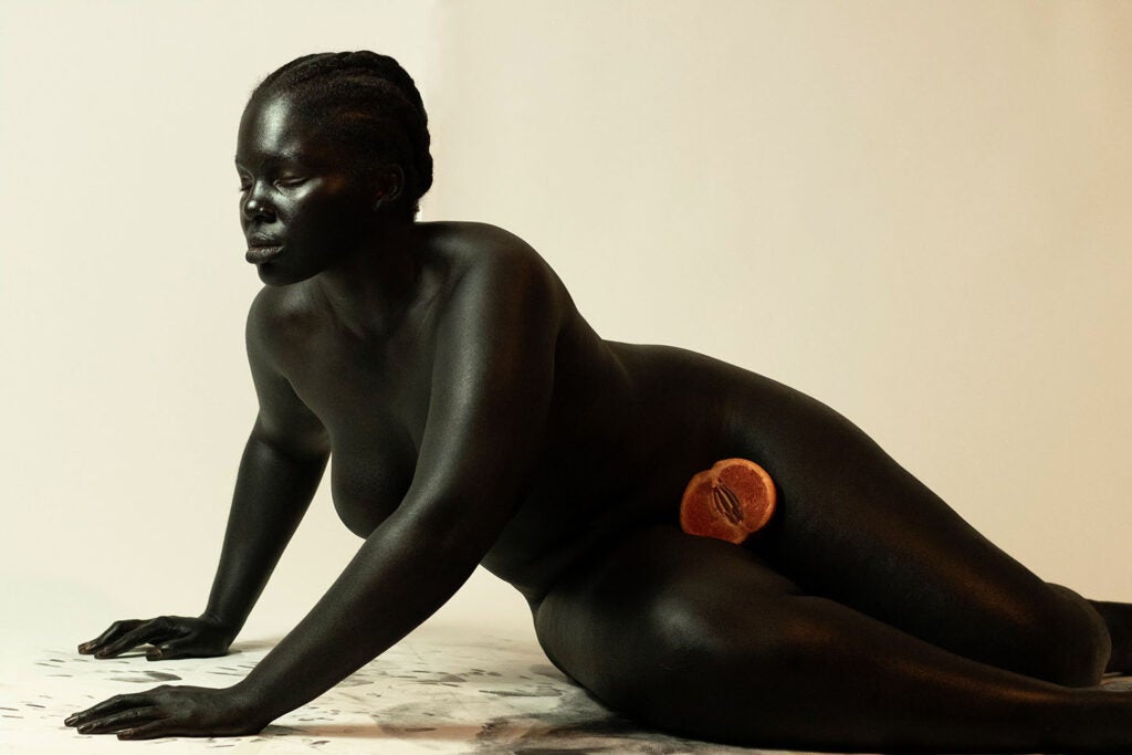 dark skinned woman hunched forward with painful expression