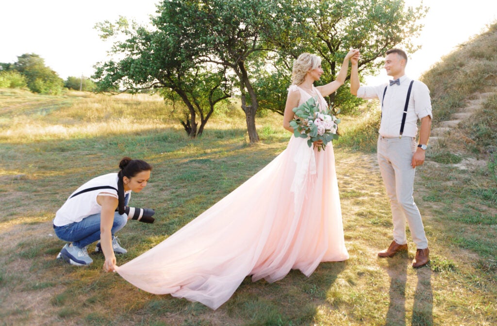 wedding photographer takes pictures of bride and groom in nature.