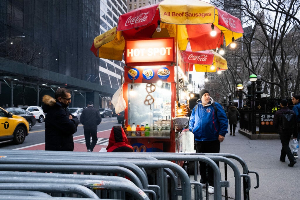 people walking near hotdog stand