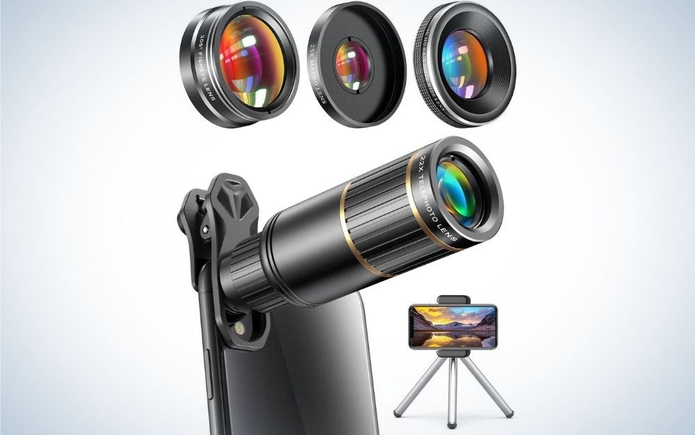 A black smartphone holder with three legs and a smartphone in it as well as some small circular lenses in neon color.