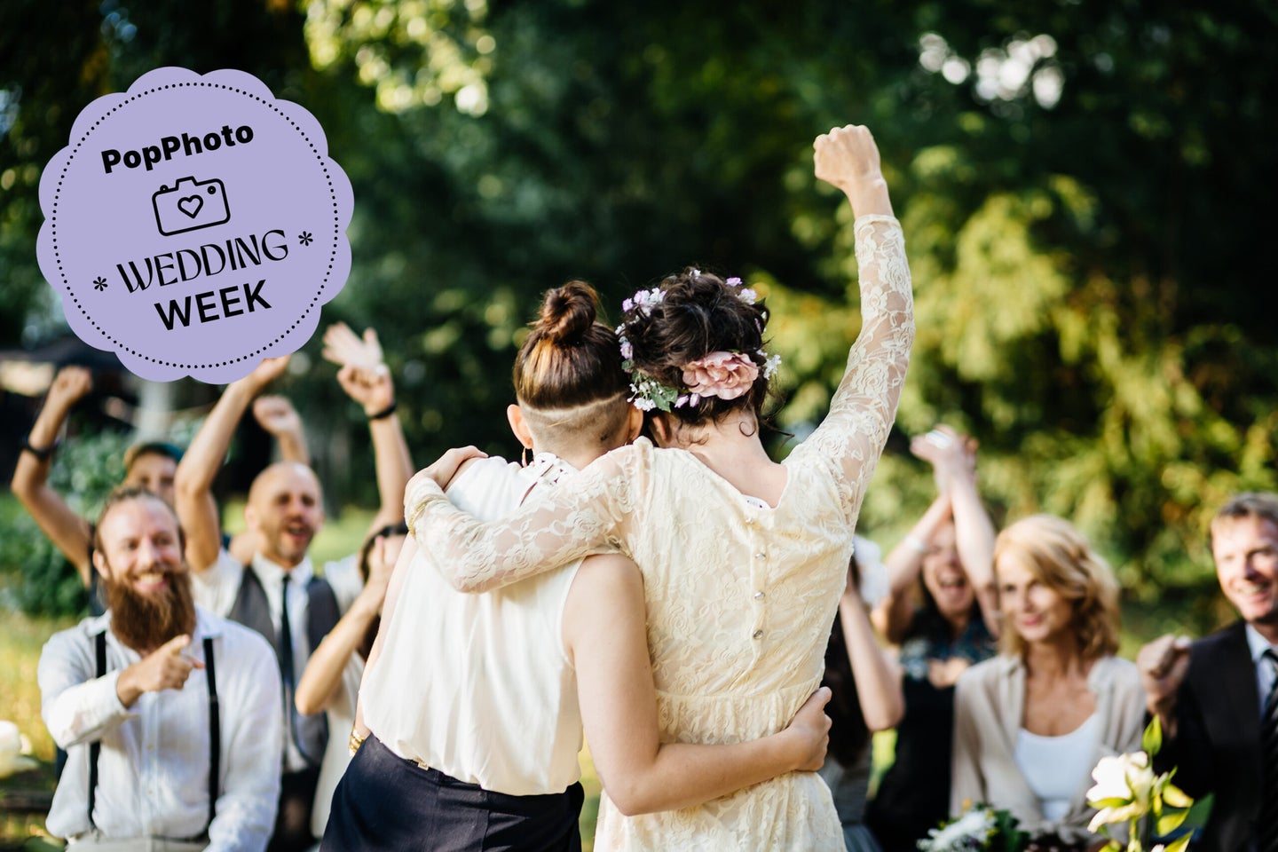 Young lesbian couple celebrating their marriage in front of their friends. The wedding ceremony is outdoors