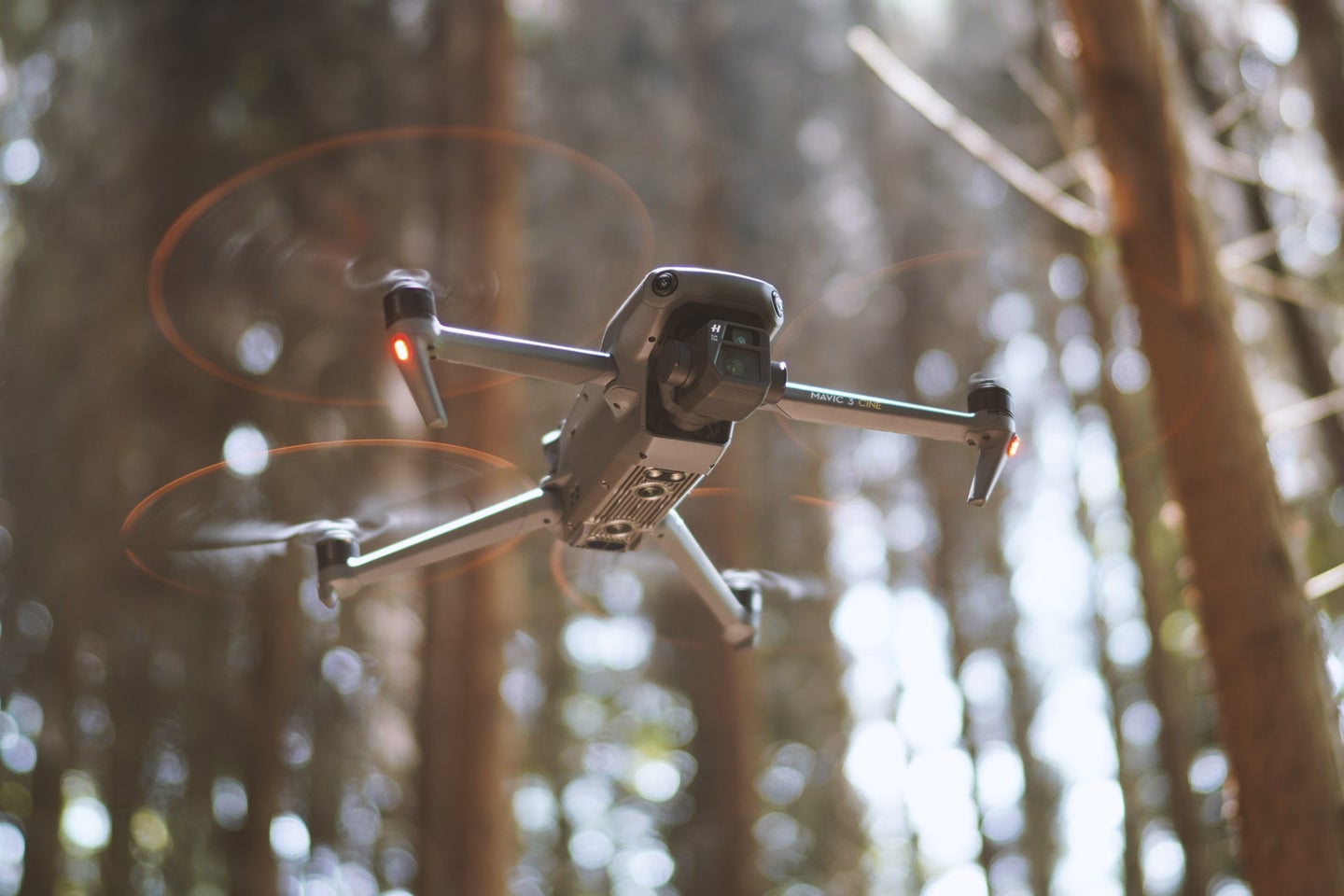 DJI drone flying in the forrest.
