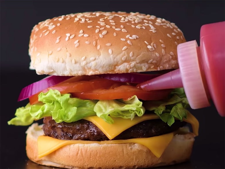 putting ketchup on a hamburger