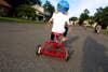 little girl on red tricycle from behind