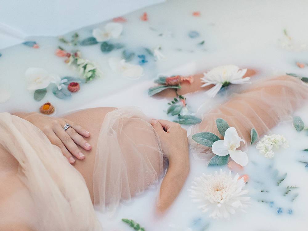 pregnant woman in a floral milk bath