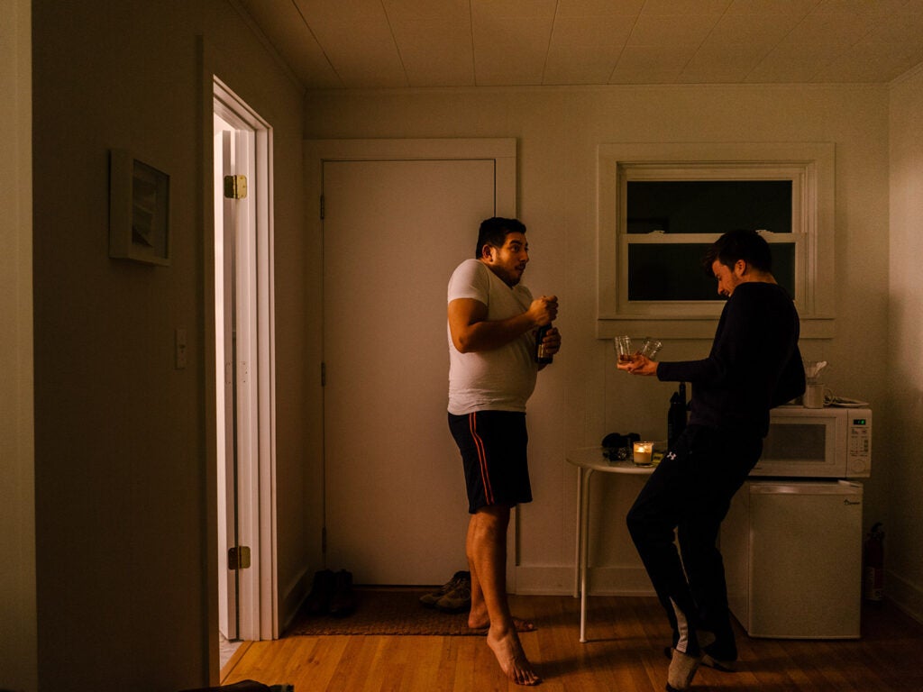 two men dancing with wine glasses