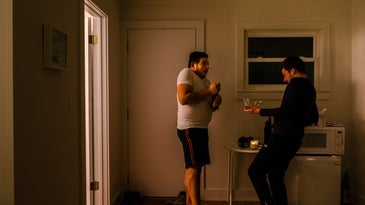 two men dancing with wine glasses