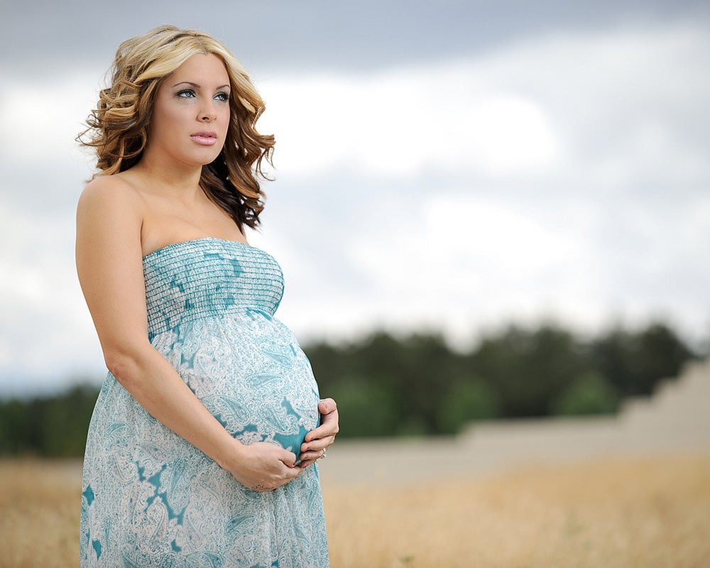 pregnant woman against a cloudy sky