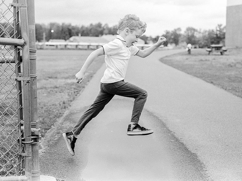 black and white photo of child jumping