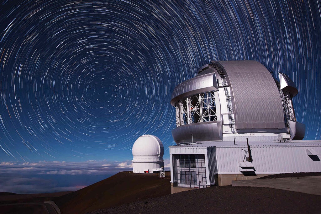 Telescopes on the summit of Mauna Kea, Hawaii with star trails in the background.  The star trail background was created from a 64 individual 30 sec files processed in PS CC. f5.6, 30 seconds, ISO 1600.  The foreground was a single exposure shot the same evening and composited into the frame. Also shot at f5.6, 30 seconds, ISO 1600.   This scene was shot on a night with a half moon above the horizon illuminating the foreground and clouds. Some minor distracting elements were cloned out.   Shot with a Nikon D800 and Nikkor 16-35mm f4.  Note this is a copy of the master file.  The master image is 7360 x 4912 pixels.