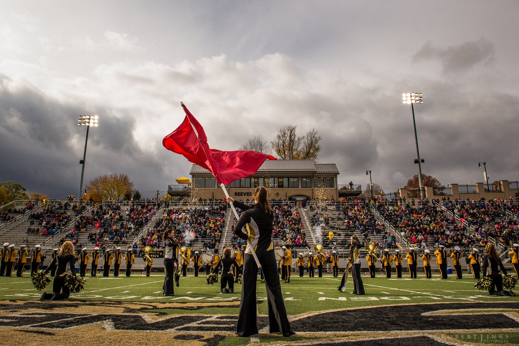 Today's Photo of the Day was submitted by reader Robert Jinks. It's a great field-level view of a marching band performance. The red flag is a great focal point set against the dramatic clouds over the field. The central location of the color guard member makes her stand out, even though she's on a crowded field of performers. See more of Robert's work on <a href="http://www.flickr.com/photos/robertjinks/">his Flickr page</a>.