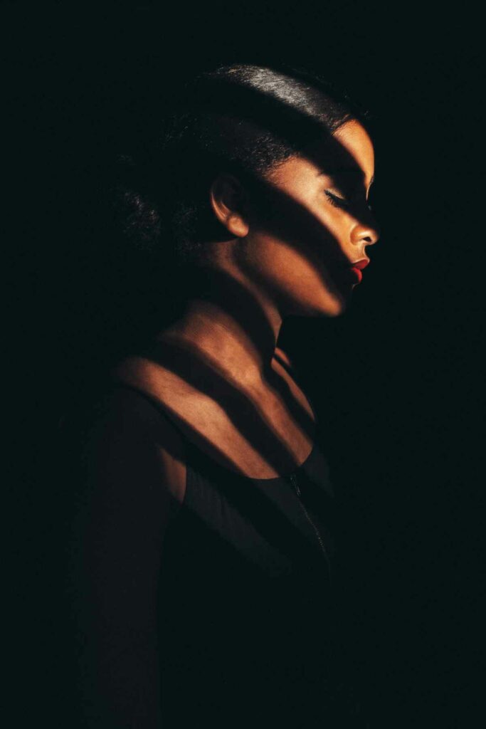 Using a large piece of cardboard as a light modifier, and exposing only for the highlights, this portrait was shot with light from the low afternoon sun to mimic the blinds of a window.