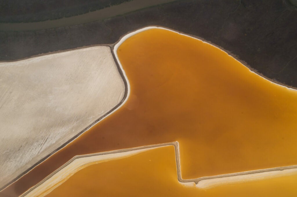 Photo: Jeffrey Goodman Shot this looking out the window of an airplane while flying over San Francisco Bay. These colorful designs are salt evaporation ponds located at the southern tip of San Francisco Bay. The differing colors come from the different types of algae that grow on top! CAMERA: Sony ILCE-5000 FOCAL LENGTH: 55mm SHUTTER SPEED: 1/1000 sec. LENS: sony 210 mm e-mount APERTURE (F-STOP): f/20