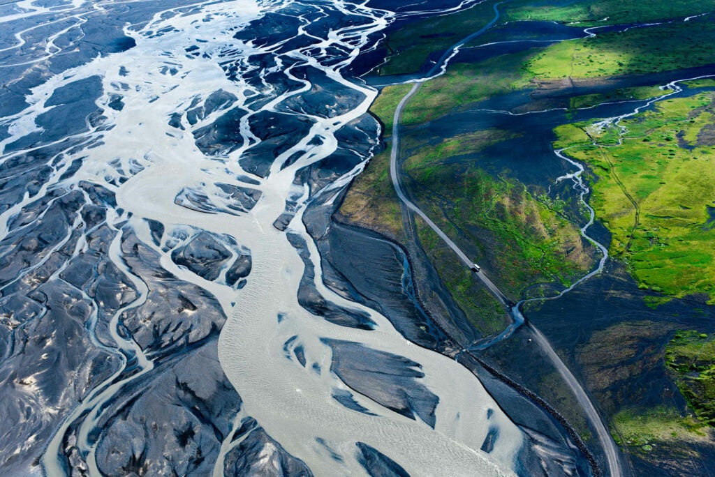 High above the glacial delta in central Iceland, a small tourist bus rumbles along a dirt road -- showcasing the true scale of this incredible land.