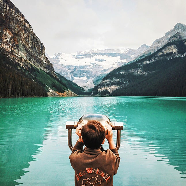 boy looking out a viewfinder at the water