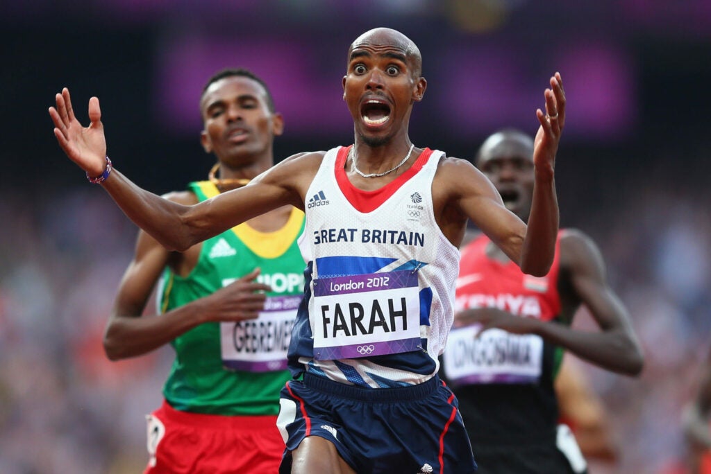 Mohamed Farah of Great Britain celebrates as he crosses the finish line to win gold ahead of Dejen Gebremeskel of Ethiopia and Thomas Pkemei Longosiwa of Kenya in the Men's 5000m Final on Day 15 of the London 2012 Olympic Games at Olympic Stadium on Augus