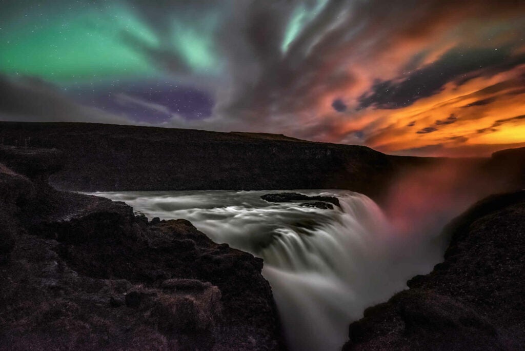 The Aurora Borealis competing with remnants of a sunset at Gullfoss, the largest waterfall in Iceland.