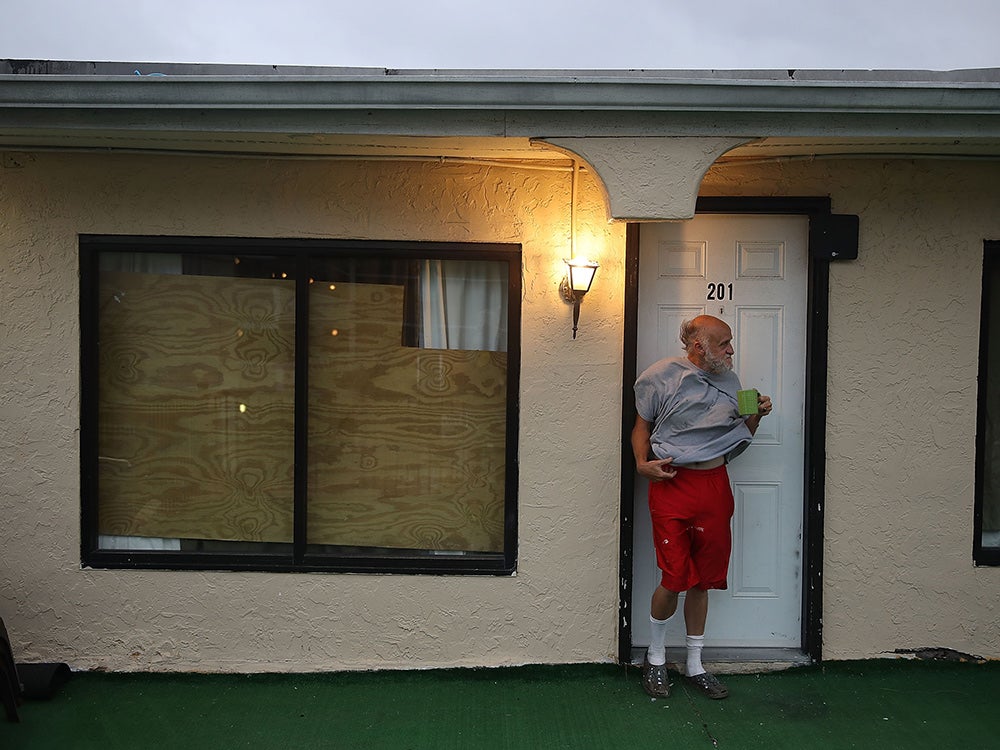 man having coffee outside house