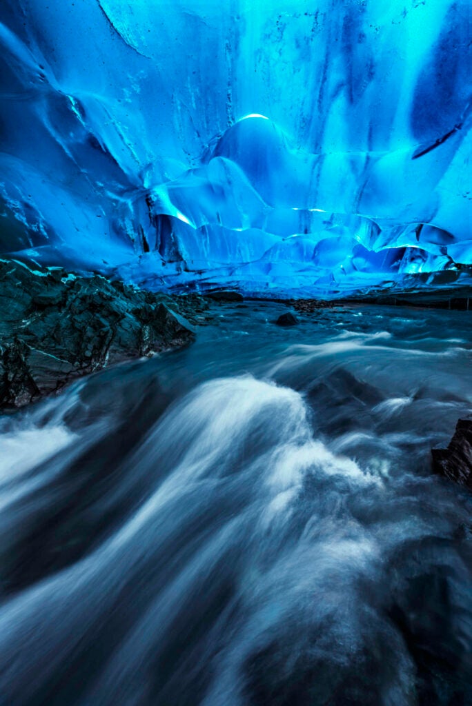 Mendenhall Glacier in Juneau, Alaska dominates the landscape in the area. Hiding under it, however, lie some intricate and beautiful caves, hidden from most peoples view. After a several mile hike out to the glacier, we had to pick our way carefully over and around the glacier until we found a small crevice that lead to this cave. Gushing glacial melt meant this water was frigid cold, and a low hanging ceiling meant a helmet was required. I didn't want to leave my tripod in the water for long, for fear of the cold water freezing the carbon fiber legs. In all it was quite worth it!