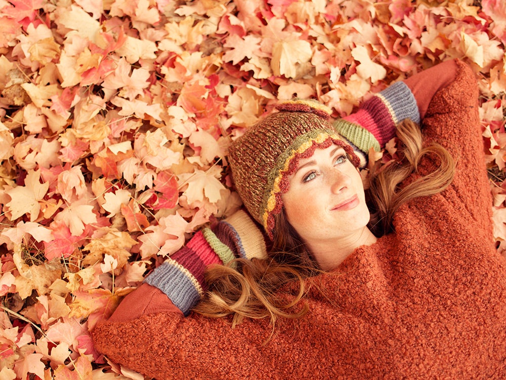 woman lying in autumn leaves