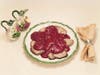 Plate of meat garnish with sauce jug and napkin