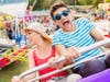 couple at fun fair riding roller coaster