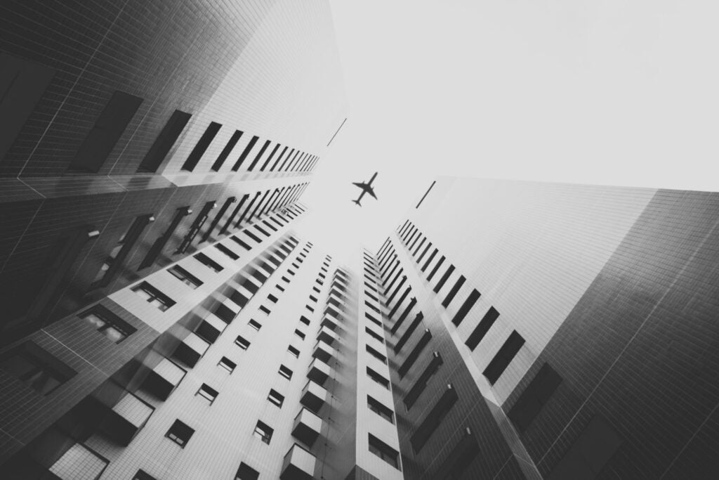 A plane flies over a building