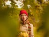 A woman wearing a knit hat and scarf in autumn