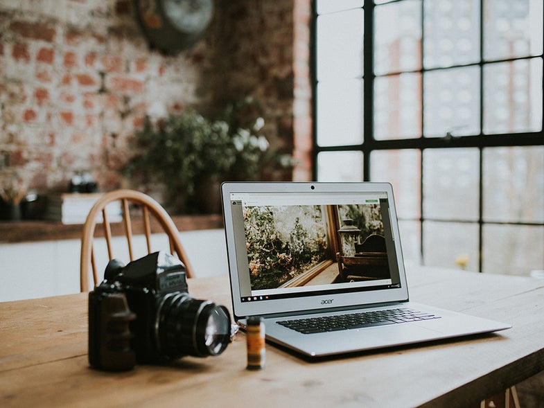 A camera next to a computer and film