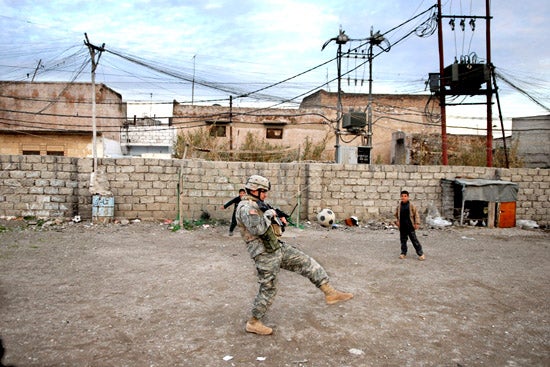 A-U.S.-soldier-tries-to-play-soccer-with-Iraqi-chi