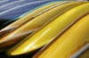 Canoes stacked along a lake.