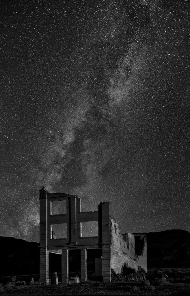 The Milky Way looms over the ruins of the old bank building in Rhyolite NV