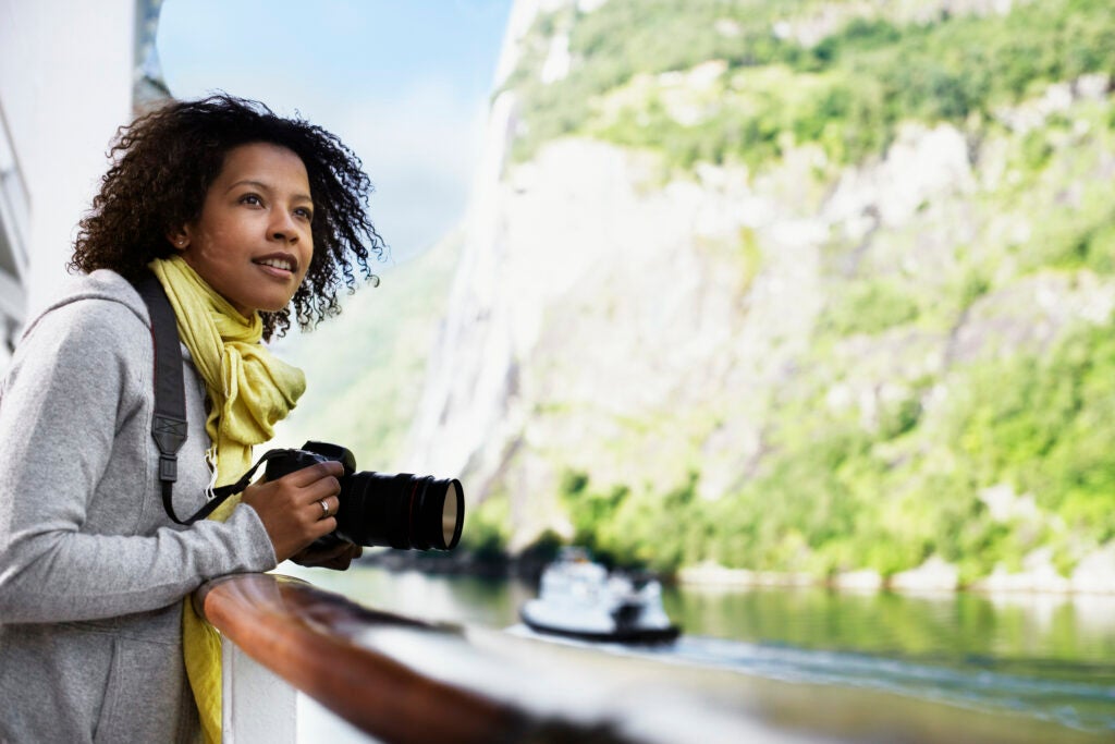 Norway --- Woman on Fjord Cruise Holding a Camera --- Image by © Tim Pannell/Corbis