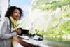 Norway --- Woman on Fjord Cruise Holding a Camera --- Image by © Tim Pannell/Corbis