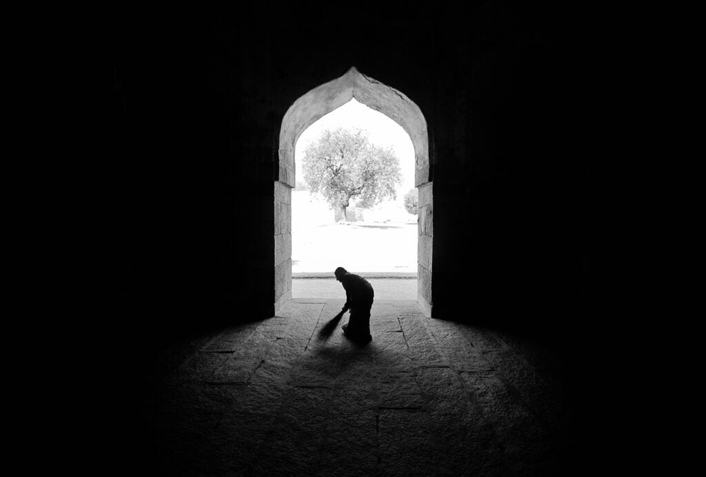 Photo: Hosain Nazari A woman cleaning stalls used by king elephants, now a tourist spot in India.