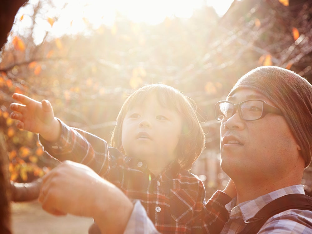 Father and son playing in the park in autumn