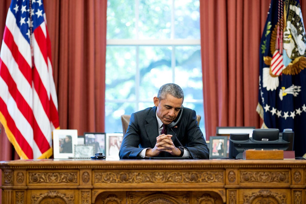 President Obama listens to a prayer during a phone call