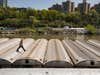 man walking on top of subway cars