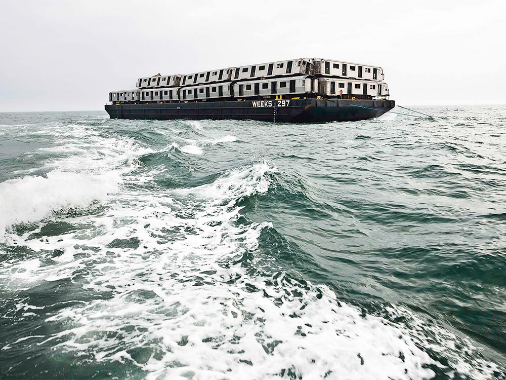 barge on the ocean carrying subway train cars